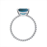 TESSA RING WITH EMERALD CUT BLUE TOPAZ IN WHITE GOLD - ANNIVERSARY & CELEBRATION RINGS